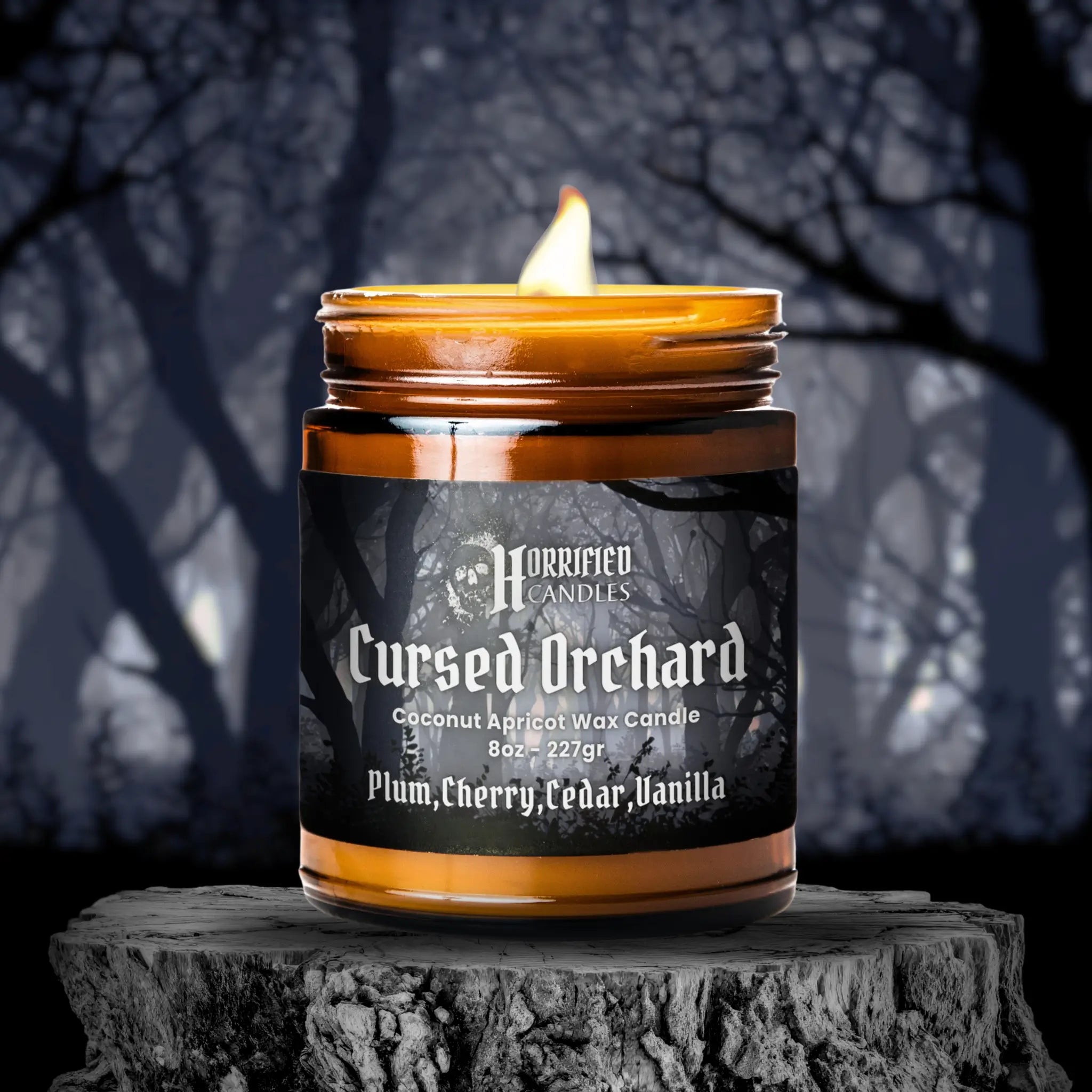 Candle labeled 'Cursed Orchard' on a dark background with tree silhouettes.
