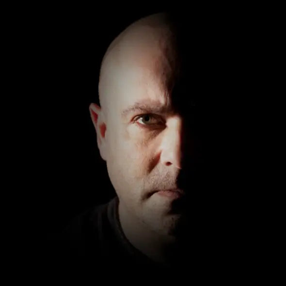 Bald man with a serious expression on a black background