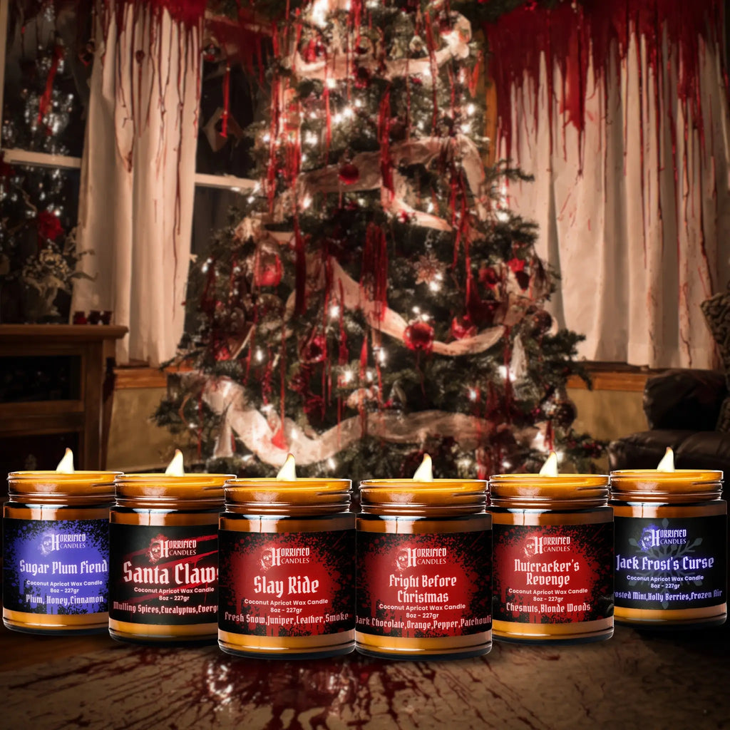 Row of candles with Halloween-themed labels in front of a decorated Christmas tree with red accents.