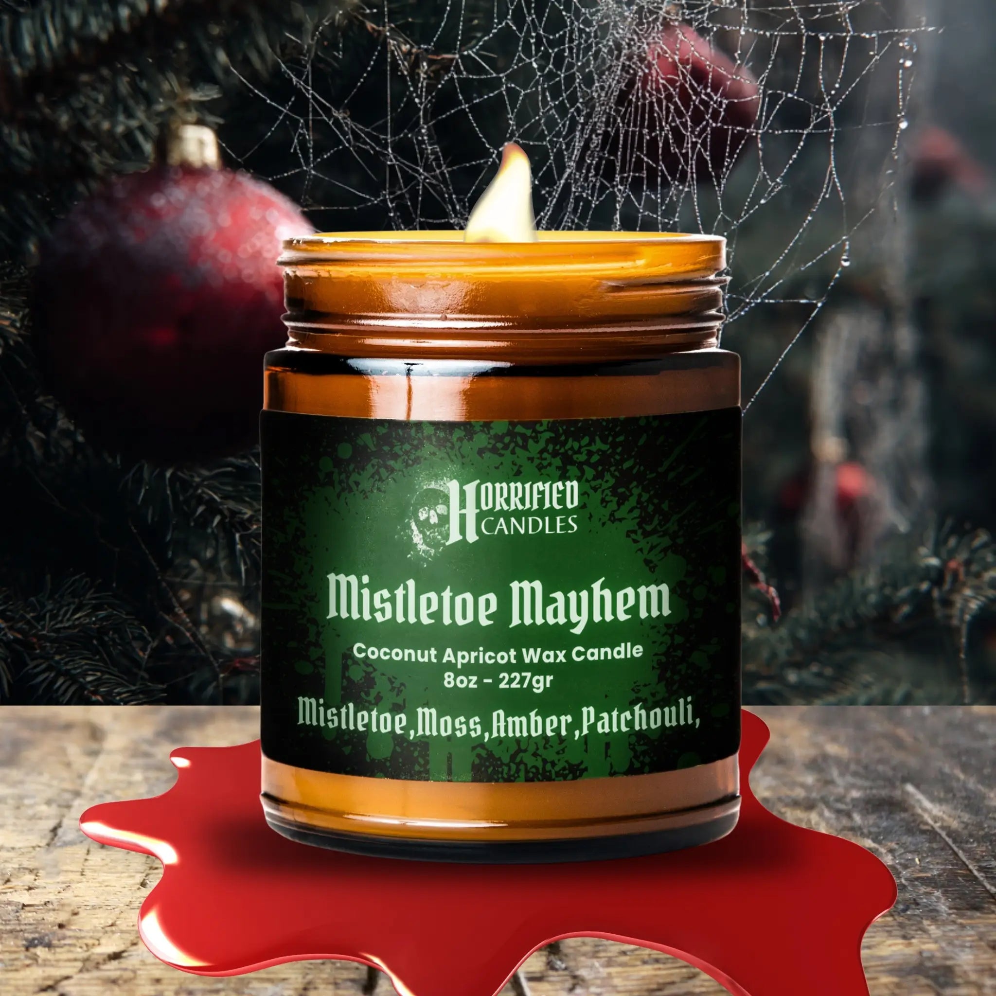 Candle labeled 'Mistletoe Mayhem' with a spider web and red berries in the background