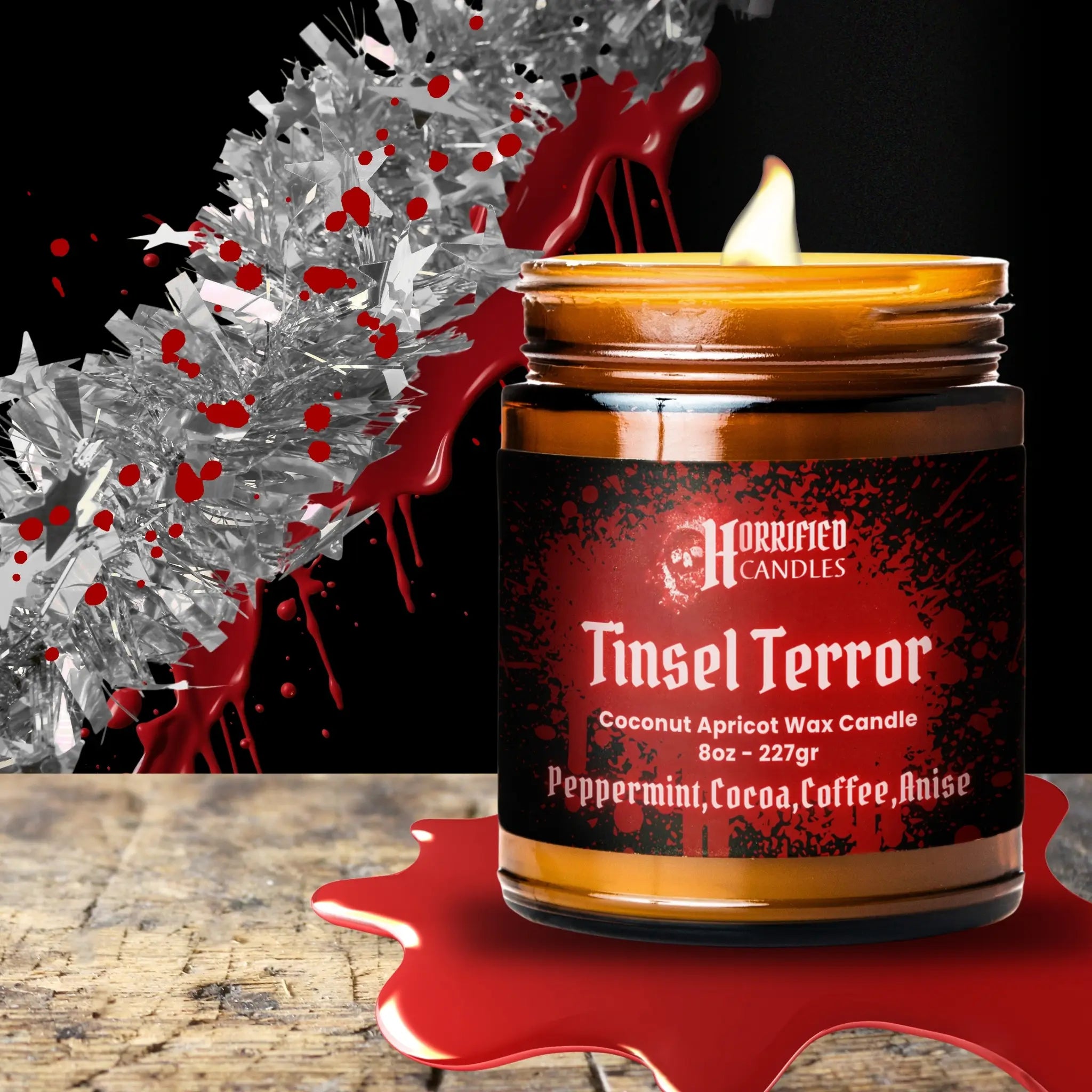 Candle labeled 'Tinsel Terror' with a dark label and red accents on a wooden surface.